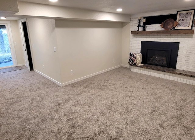 basement with a fireplace and carpet