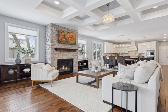 living area featuring a fireplace, coffered ceiling, dark wood-type flooring, and beamed ceiling