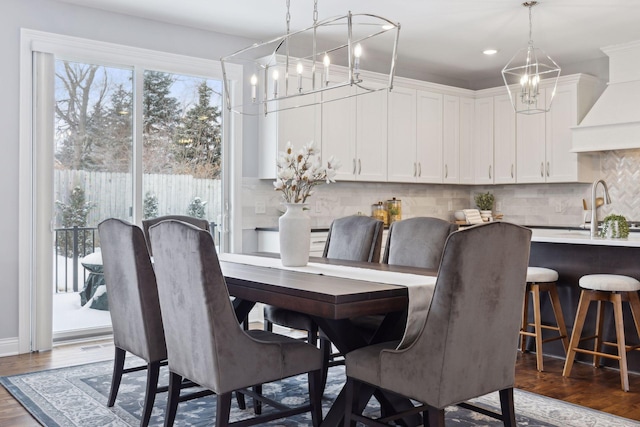 dining space with dark wood-style flooring and a notable chandelier