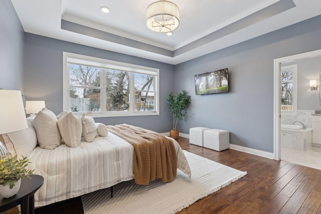 bedroom featuring connected bathroom, dark wood-type flooring, baseboards, a raised ceiling, and an inviting chandelier