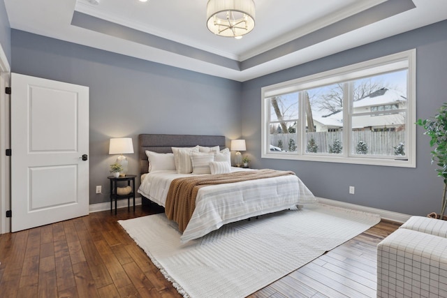 bedroom with a tray ceiling, dark wood-style flooring, baseboards, and an inviting chandelier