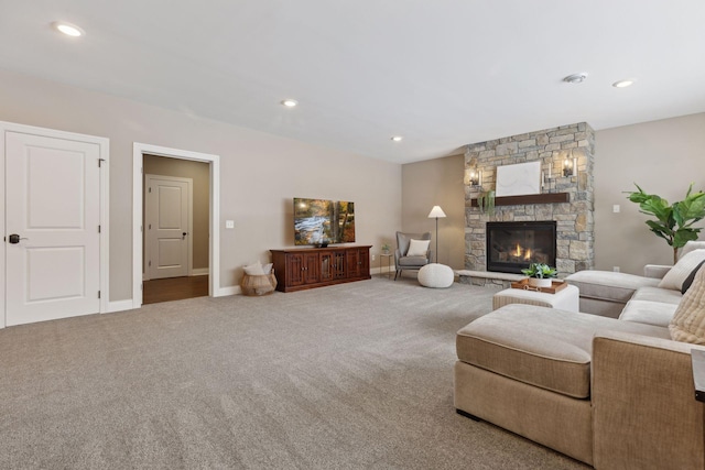 carpeted living room featuring baseboards, a stone fireplace, and recessed lighting