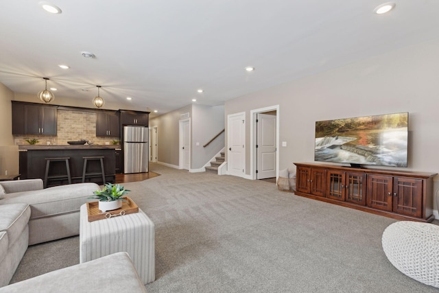 living room with recessed lighting, light carpet, stairway, and baseboards