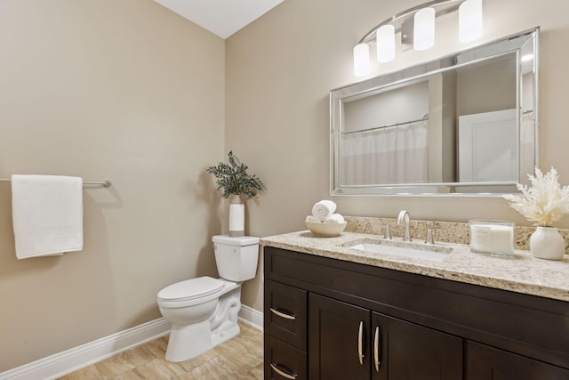 full bathroom with vanity, toilet, and baseboards