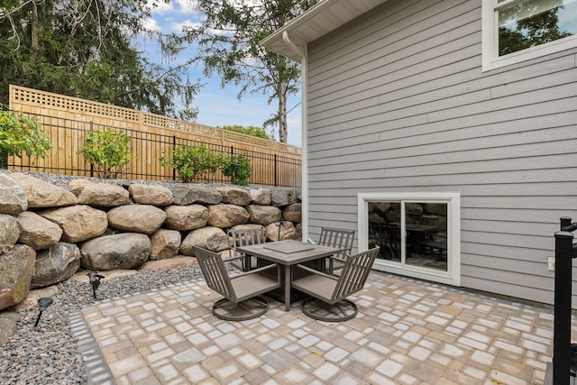 view of patio featuring outdoor dining space and fence