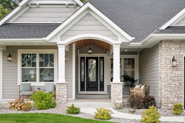 property entrance with covered porch and roof with shingles