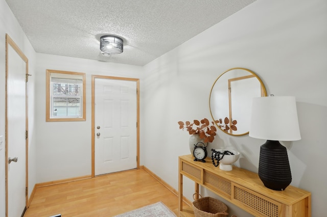 foyer with light hardwood / wood-style flooring and a textured ceiling