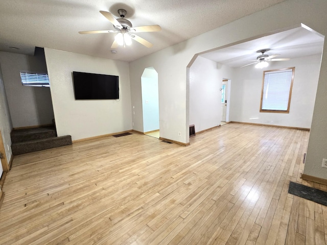 unfurnished living room featuring a textured ceiling, light hardwood / wood-style floors, and ceiling fan