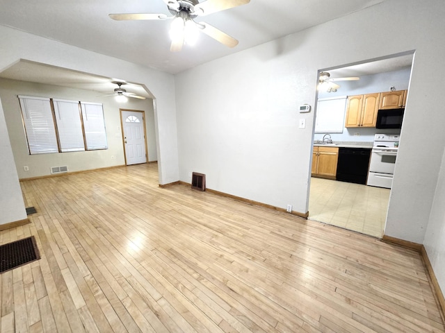 unfurnished living room with light hardwood / wood-style floors and sink