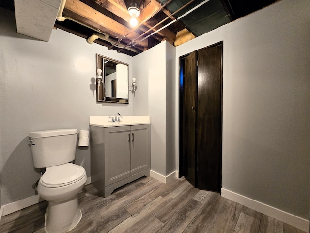 bathroom with vanity, toilet, and wood-type flooring