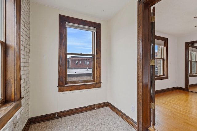 corridor featuring wood finished floors and baseboards