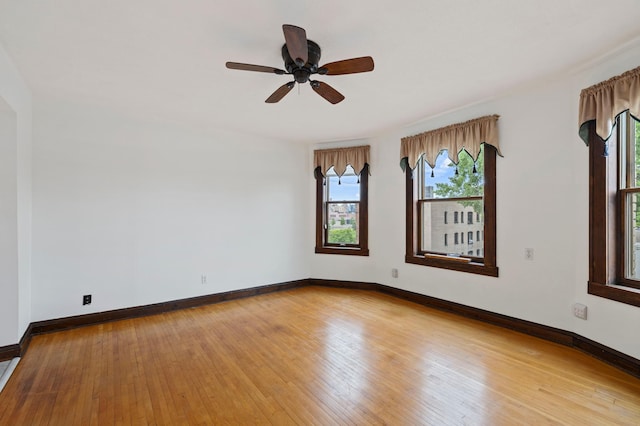 unfurnished room with baseboards, light wood finished floors, and ceiling fan