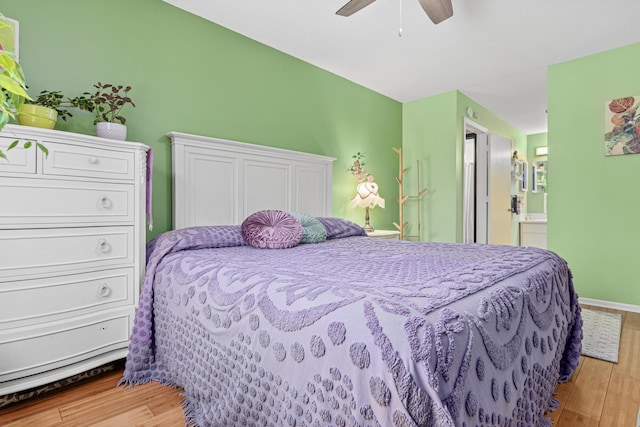 bedroom featuring ceiling fan, light hardwood / wood-style floors, and connected bathroom