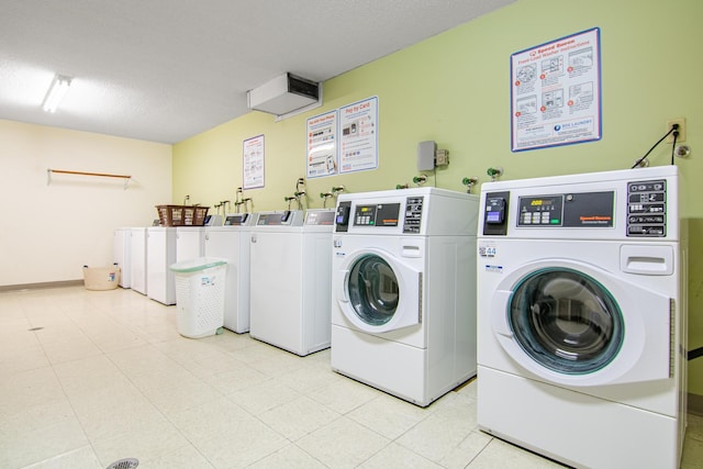 laundry room with a textured ceiling and washer and clothes dryer