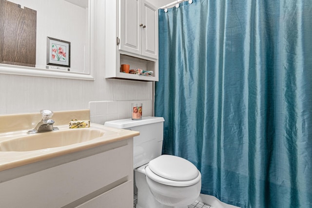 bathroom featuring vanity, tile patterned floors, and toilet