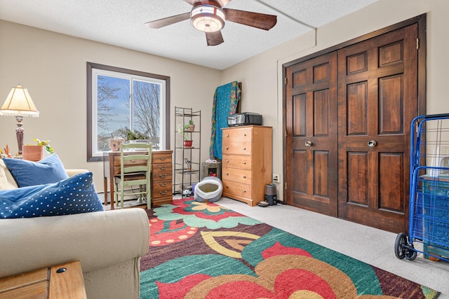 bedroom featuring ceiling fan, carpet flooring, a textured ceiling, and a baseboard heating unit