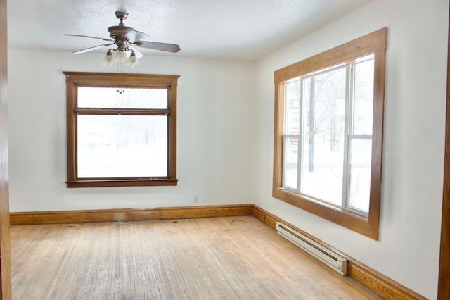 empty room with light wood-type flooring, baseboard heating, and ceiling fan