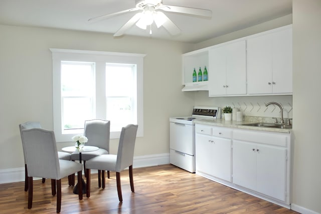 kitchen with plenty of natural light, stove, white cabinetry, and sink