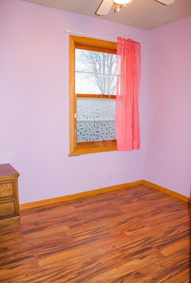 empty room featuring hardwood / wood-style floors, a textured ceiling, and ceiling fan