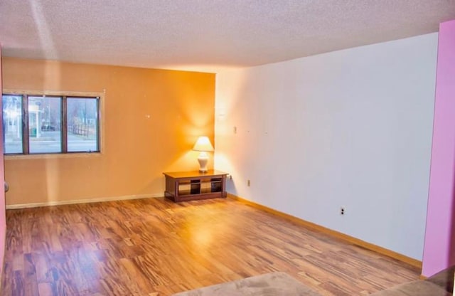 spare room with a textured ceiling and hardwood / wood-style flooring