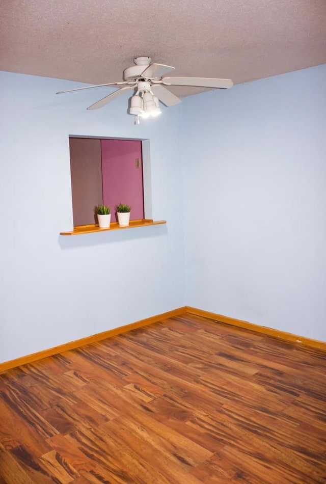 spare room featuring a textured ceiling and hardwood / wood-style flooring