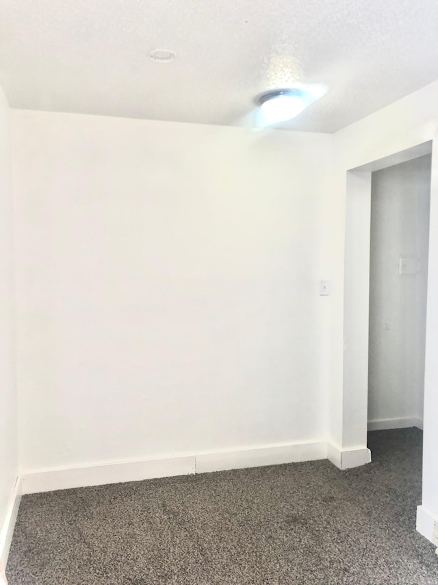 carpeted empty room featuring a textured ceiling