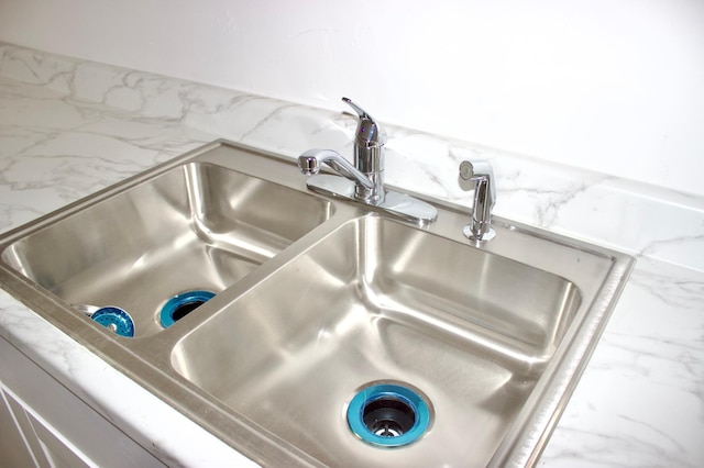 interior details featuring light stone countertops and sink