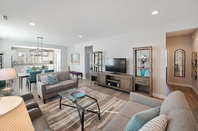 living room with light hardwood / wood-style floors and a chandelier