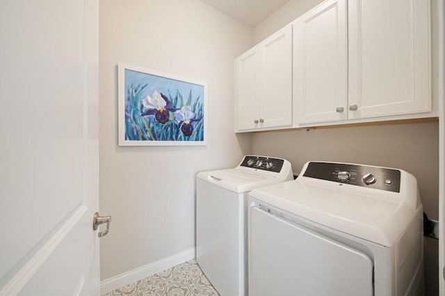 laundry room with cabinets, light tile patterned floors, and washing machine and clothes dryer