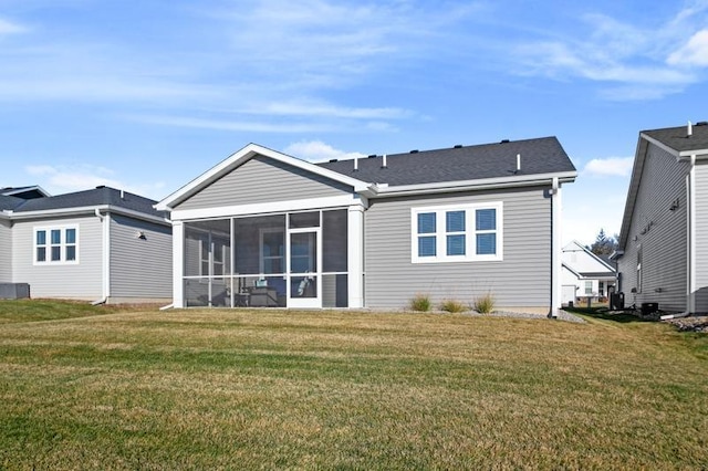 rear view of property with a sunroom and a lawn