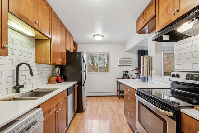 kitchen with appliances with stainless steel finishes, light hardwood / wood-style flooring, plenty of natural light, and sink