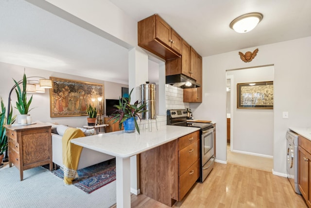 kitchen featuring backsplash, kitchen peninsula, stainless steel appliances, and light hardwood / wood-style flooring