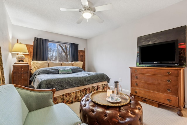 bedroom with ceiling fan, carpet, and a textured ceiling