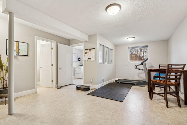 workout area featuring a textured ceiling and washer / dryer