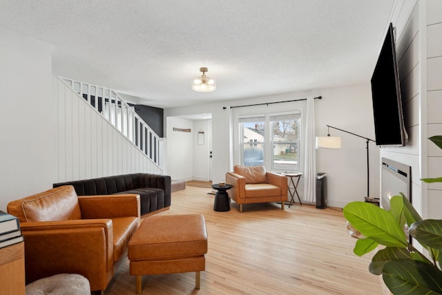 living room featuring a textured ceiling and light wood-type flooring