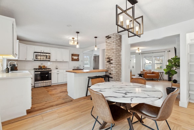 dining room featuring a notable chandelier, light hardwood / wood-style floors, and sink