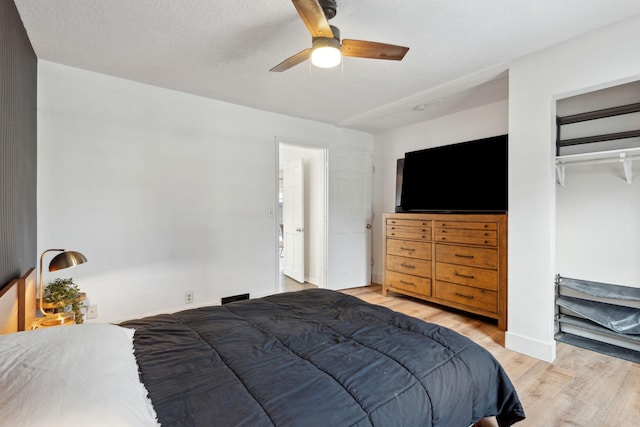 bedroom with ceiling fan, a closet, a textured ceiling, and light hardwood / wood-style flooring