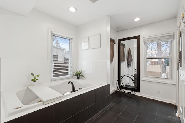 bathroom featuring tiled bath and tile patterned flooring