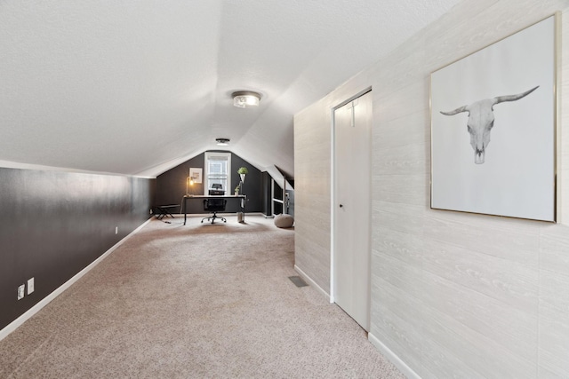 additional living space with carpet flooring, a textured ceiling, and lofted ceiling