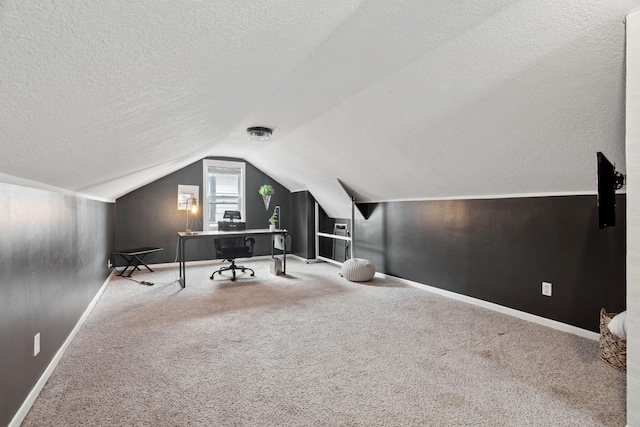 office area with a textured ceiling, carpet floors, and vaulted ceiling