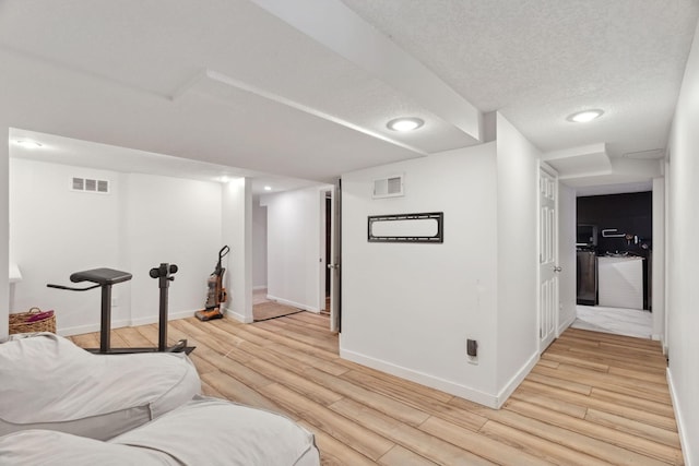 living room with light wood-type flooring and a textured ceiling