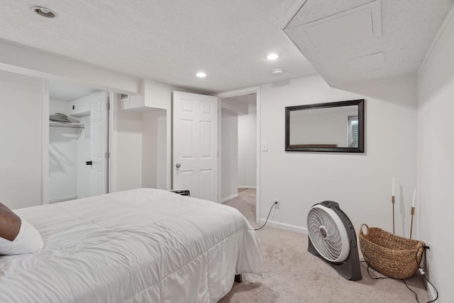 carpeted bedroom with a spacious closet, a closet, and a textured ceiling