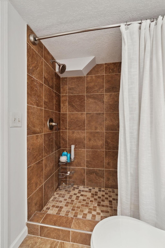 bathroom with toilet, a textured ceiling, tile patterned floors, and curtained shower