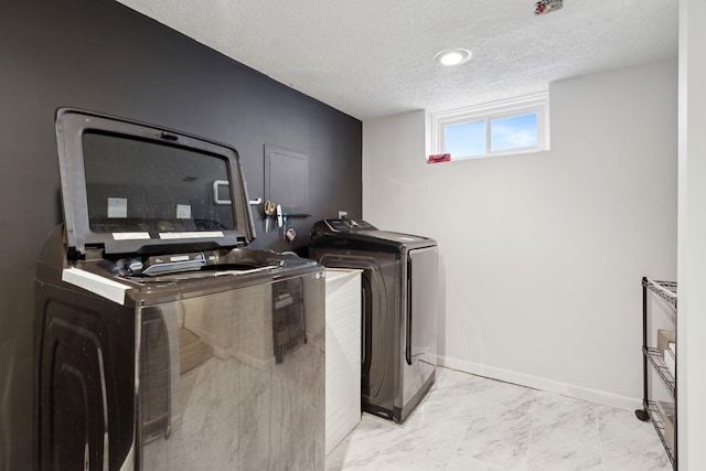 laundry area featuring washer / dryer and a textured ceiling