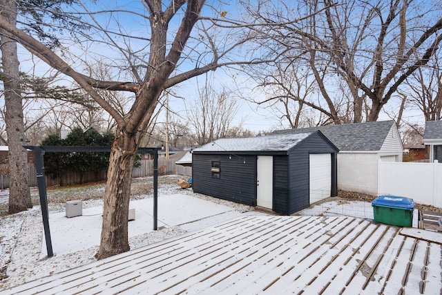 snow covered deck with an outbuilding and a garage