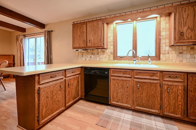 kitchen featuring dishwasher, sink, decorative backsplash, light wood-type flooring, and kitchen peninsula