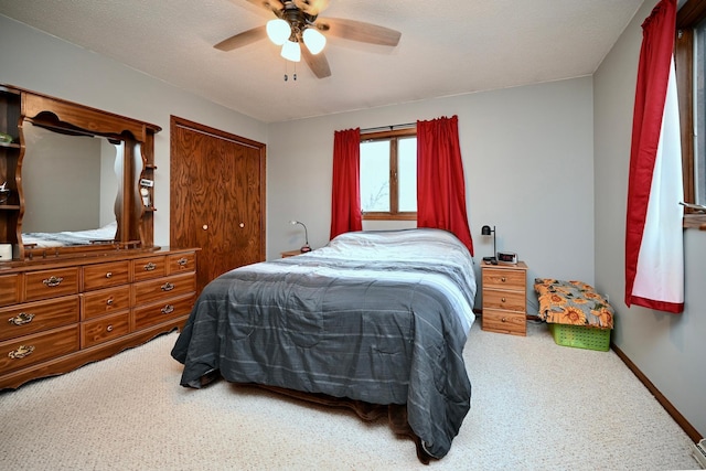 bedroom with ceiling fan, carpet, and a textured ceiling