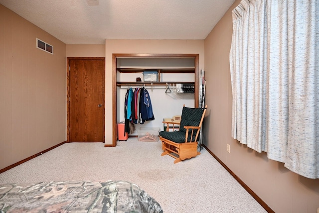 bedroom with carpet flooring, a closet, and a textured ceiling