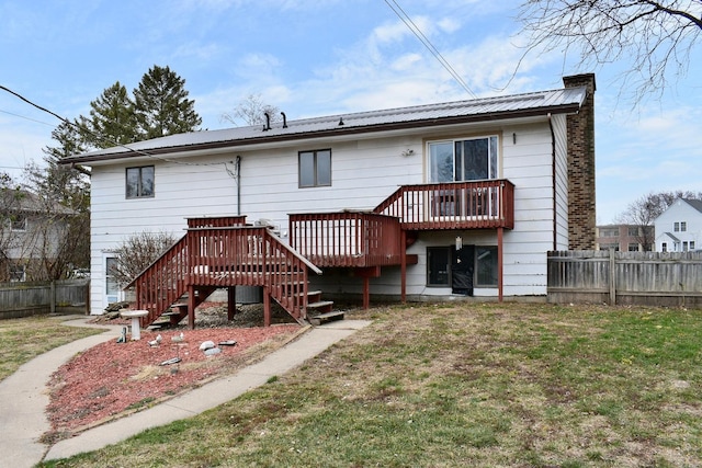 rear view of property with a wooden deck and a yard