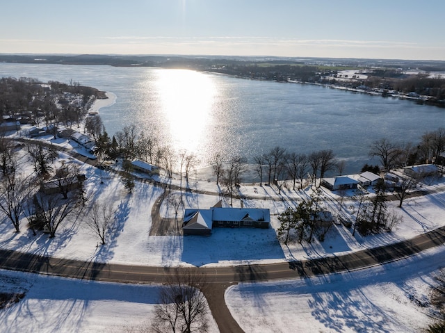 snowy aerial view featuring a water view